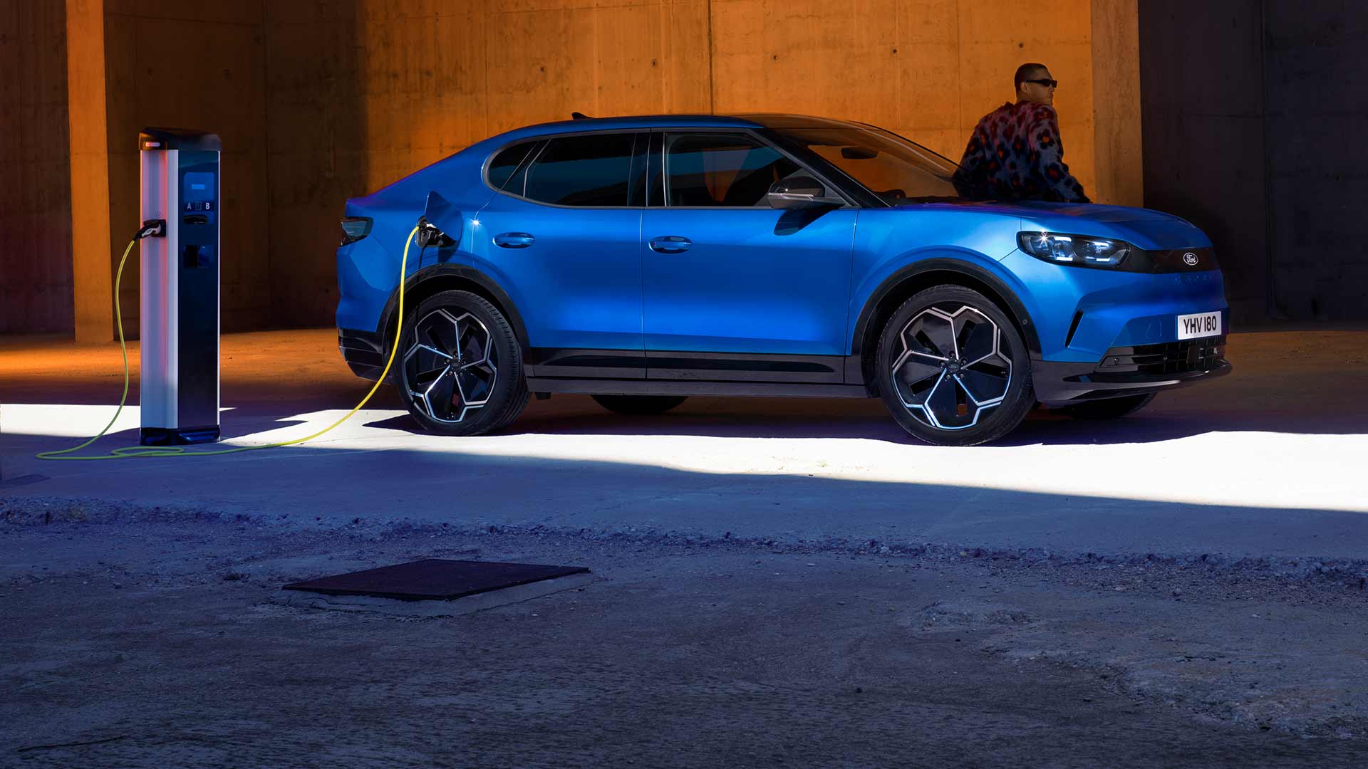 Blauwe elektrische Ford Capri® aangesloten op een openbaar EV-laadpunt.