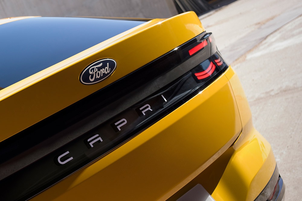 Een close-up van de CAPRI-letters op de achterkant van de nieuwe gele elektrische Ford Capri® SUV. 